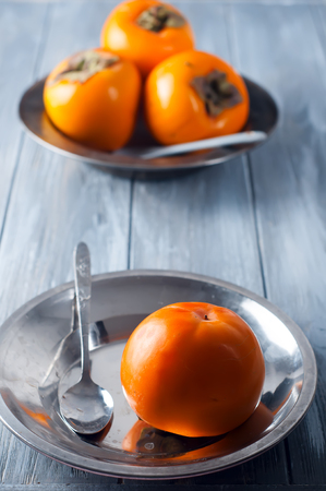 Delicious fresh persimmon fruit on wooden table.の写真素材
