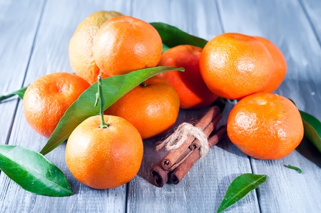 Tangerines with leaves and cinnamon on gray wooden table.の写真素材