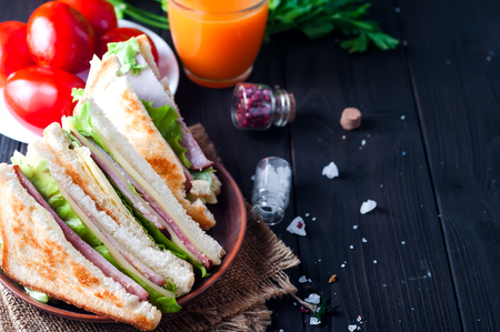 homemade sandwich with salad and juice as a healthy breakfast on a dark background. Space for textの写真素材