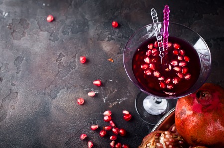 pomegranate cocktail and ripe red pomegranate fruit on the dark backgroundの写真素材