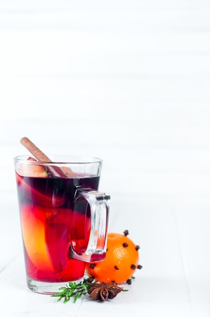 Mulled wine with cinnamon sticks and tangerine on a white wooden background. Copy spaceの写真素材