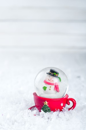 A snow globe with snowman isolated on a white snow backgroundの写真素材