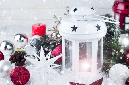 Cristmas lantern with decorations and snow over white shabby wooden backgroundの写真素材