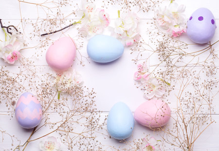 Colorful Easter eggs and flowers on paper with space for text. Top viewの写真素材