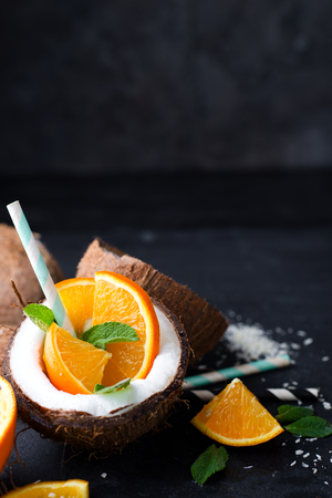 Pina colada drink with orange on dark stone background, copy spaceの写真素材