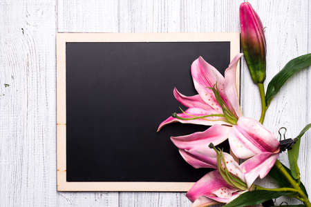 Spring background. Chalkboard with flowers on wood, flat layの写真素材