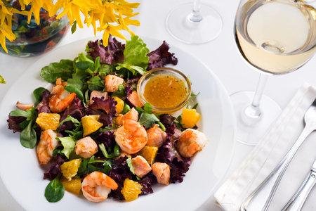 Healthy Shrimp and Salad with orange and Tomatoes, wine on a white backgroundの写真素材