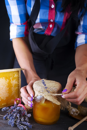 womens hands hold a jar of honeyの写真素材