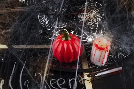 Pumpkin, candle and a long glass with a red cocktailの写真素材