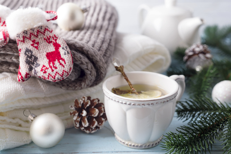 A cup of tea for the new year. A cozy plaid, a knitted scarf and hot tea create a New Year's mood.の写真素材
