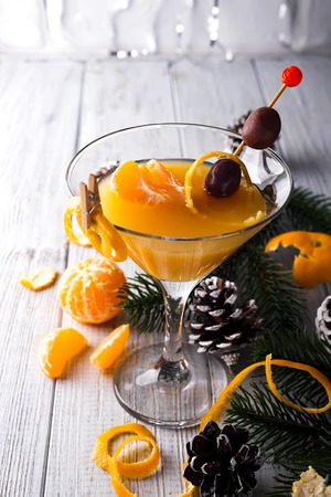 Mandarin martini in a glass of New Year or Christmas on a white wooden background, a place under the textの写真素材