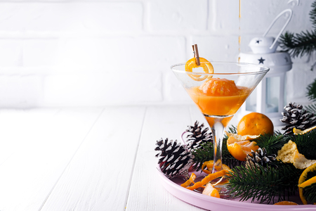 martini in a glass on a iron tray with pine cone and spruce branches, Concept of New Year or Christmas on a white wooden background,copy spaceの写真素材
