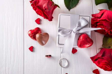 Fresh red roses and gift box on wooden tableの写真素材