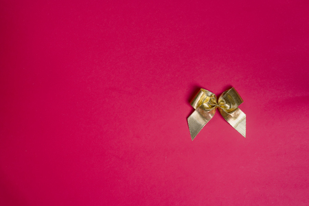 Stylish gold bow glittering on red background, flat lay copy spaceの写真素材