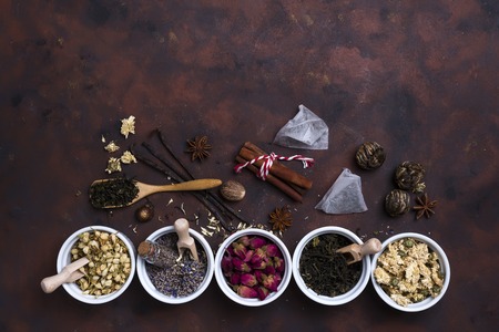 Collection of tea and natural additives in bowls on old wooden table, flat lay copy spaceの写真素材