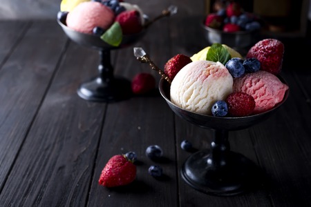 Bowl with ice cream with three different scoops of white, yellow and red colors,の写真素材