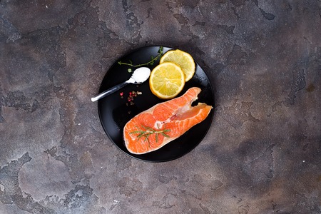 Salmon steaks on ice withlemon slice on wooden plateの写真素材