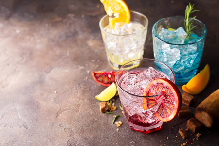 Orange cocktail with ice, leaf of mint and orange slice on black stone background, copy spaceの写真素材