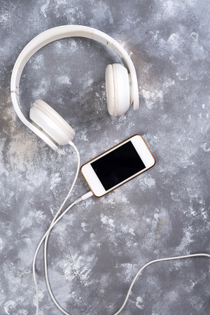 Headset and a phone on a stone background. Ready to listen to music.の写真素材