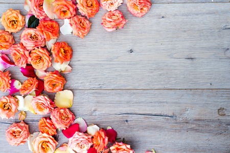 Floral pattern, frame made of roses on wooden background. Flat lay, top view. Valentines background.の写真素材