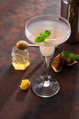 The rose exotic cocktail and figs, honey on brown stone background , copy spaceの写真素材