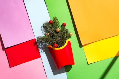 Top view red box on multicolor paper background with with Christmas tree branches and colored balls. Christmas, winter and holidays season concept.の写真素材