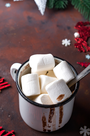Winter hot drink close up. Hot chocolate or cocoa with marshmallow and spices on dark stone background.の写真素材