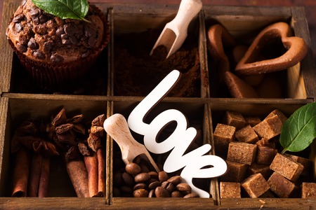 Spices, coffee and cookies in wooden box on a dark stone backgroundの写真素材