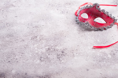 Flat lay image of beautiful red carnival mask for carnival holiday background concept on stone, copy spaceの写真素材