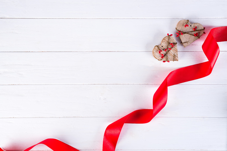 Happy Valentines Day. Red Ribbon and two wooden Hearts on white background. Valentines Day conceptの写真素材