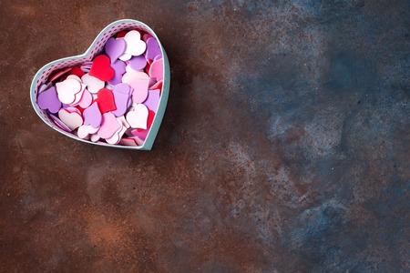 Open empty gift box with a hearts shape on stone background, flat lay.