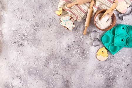 Baking accessories on stone  with flour and easter glazed cookies