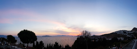 Panoramic beach sunset with endless horizon and incredible foamy waves.の写真素材