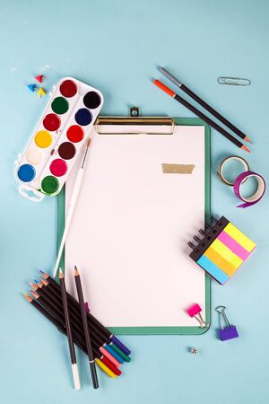 Clipboard and office or school supplies over blue background, flat lay. Back to schoolの写真素材