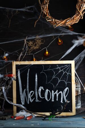 Antique candelabra with melting candle, spider web and a syringe with tomato juice on black background. Halloween party decorationの写真素材