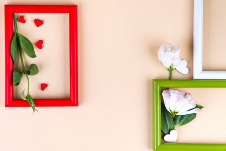 Empty color frames, red hearts and flowers eustoma on beige paper   with copy space. Love conceptの写真素材