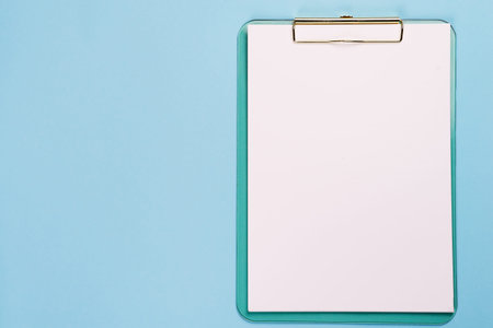 Blank clipboard mock up on pastel blue color background with copy space, flat lay
