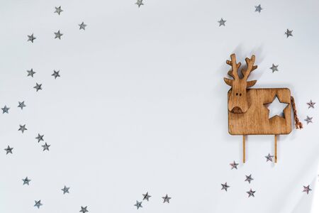 Christmas background. Decorative wooden deer on stars white background. Copy space, top viewの写真素材