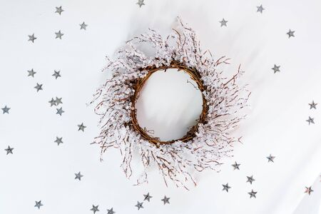 Christmas wreath branches of frost on white background with sunlight rays and stars, flat lay copy spaceの写真素材
