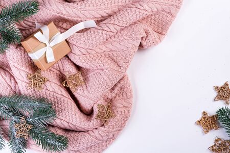 Pink knitted sweater with gift box, christmas decoration and fir branches on a white background, top view. Christmas still lifeの写真素材
