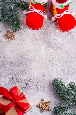 santa claus shoes, fir branches and gift box with red ribbons on a srone background, copz space, top viewの写真素材