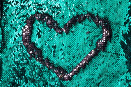 Heart sign frame on a sequins green glitter  texture, copy spaceの写真素材