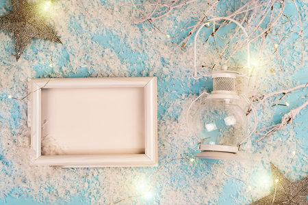 White christmas lantern with white photo frame in the snow and blue  with stars