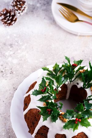 Christmas homebaked dark chocolate bundt cake decorated with holly berry branches on stoneの写真素材