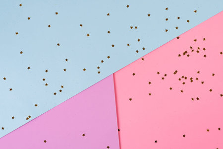 Golden stars on pink blue background. Holiday background. Minimal concept. Flat lay. Top view.