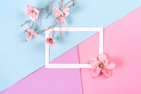 Artificial flowers with white paper frame on three color paper background. Holiday conceptの写真素材