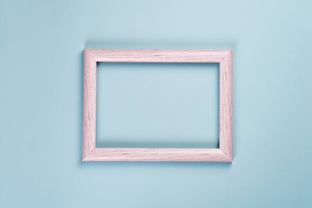 Blank old wooden frame for photos or different pictures on a pastel blue background.の写真素材