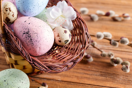 Greeting Easter card from wicker basket of handmade painted chicken and quail eggs with willow twigs...