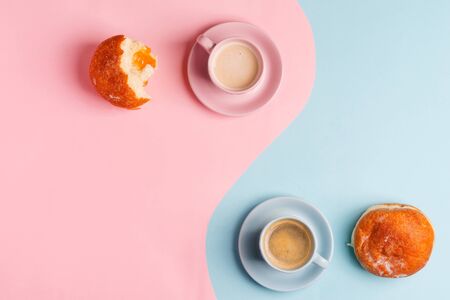 Breakfast backdrop with two cups of coffee and homemade freshly baked doughnuts on a duotone pastel pink blueの写真素材