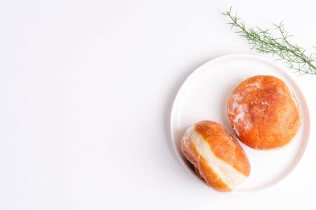 Homemade baked donut on a white ceramic plate on a light greyの写真素材